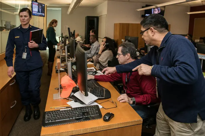 man in blue jacket using computer